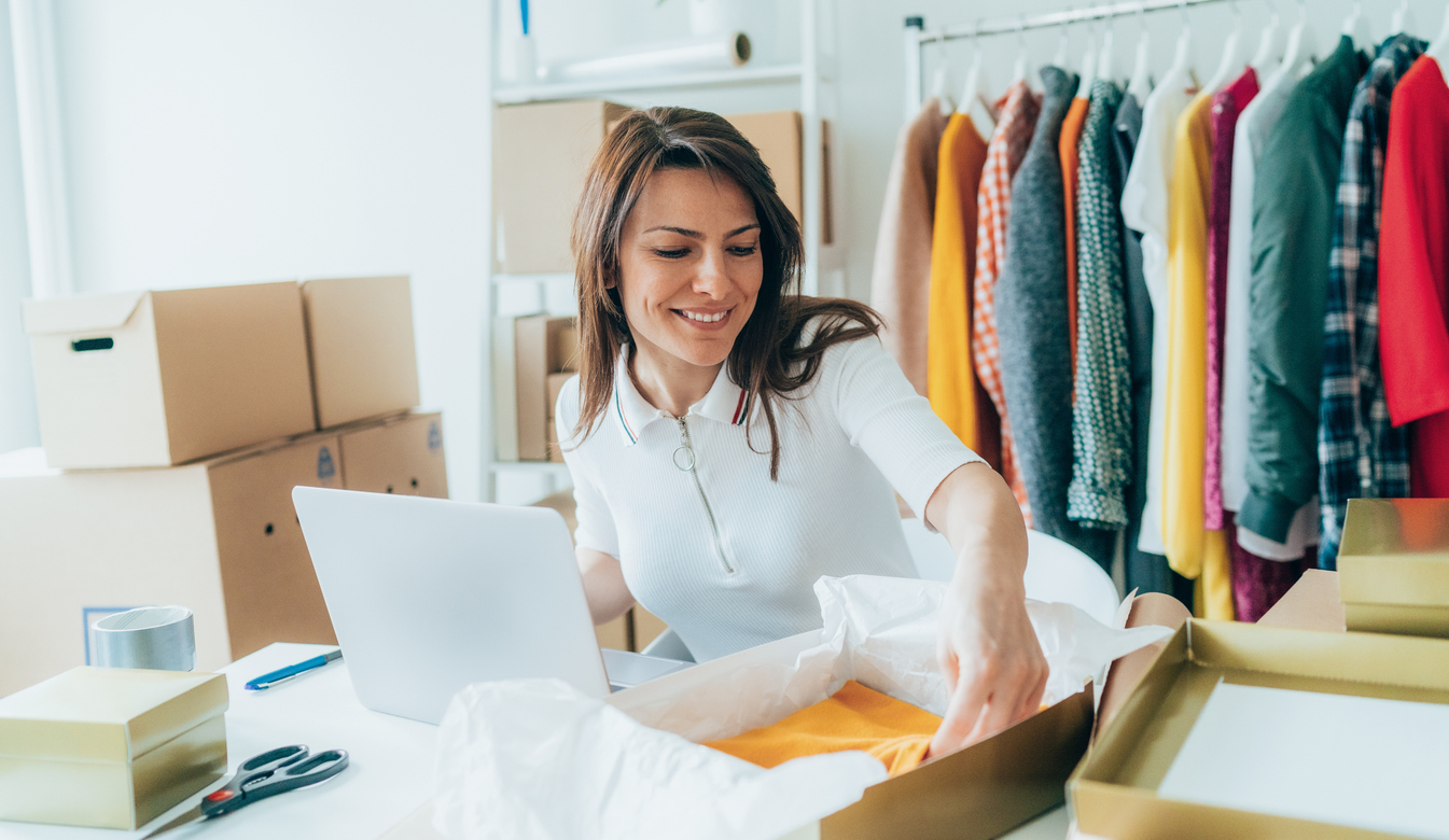 Woman packing clothes at a warehouse for apparel fulfillment services