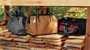 Righteous Clothing Agency branded work bags displayed on stacked lumber, built for durability on the job.
