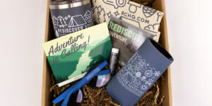 Righteous’ new hire welcome kit with tumbler, koozie, sunglasses, postcard, and lip balm.