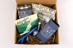 Righteous’ new hire welcome kit with tumbler, koozie, sunglasses, postcard, and lip balm.