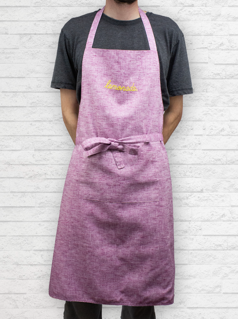Cafe worker wearing Righteous Clothing Agency pink apron with “lemonade” embroidery and waist tie.