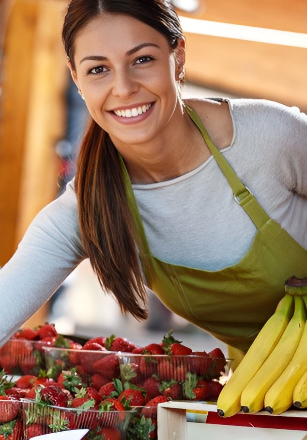 Smiling cafe barista wearing Righteous Clothing Agency apparel picking strawberries.