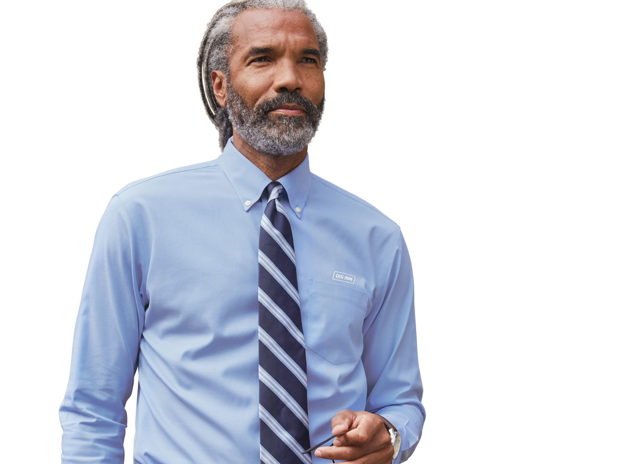 Man wearing a Righteous Clothing Agency light blue dress shirt and striped tie, holding glasses against a black background.