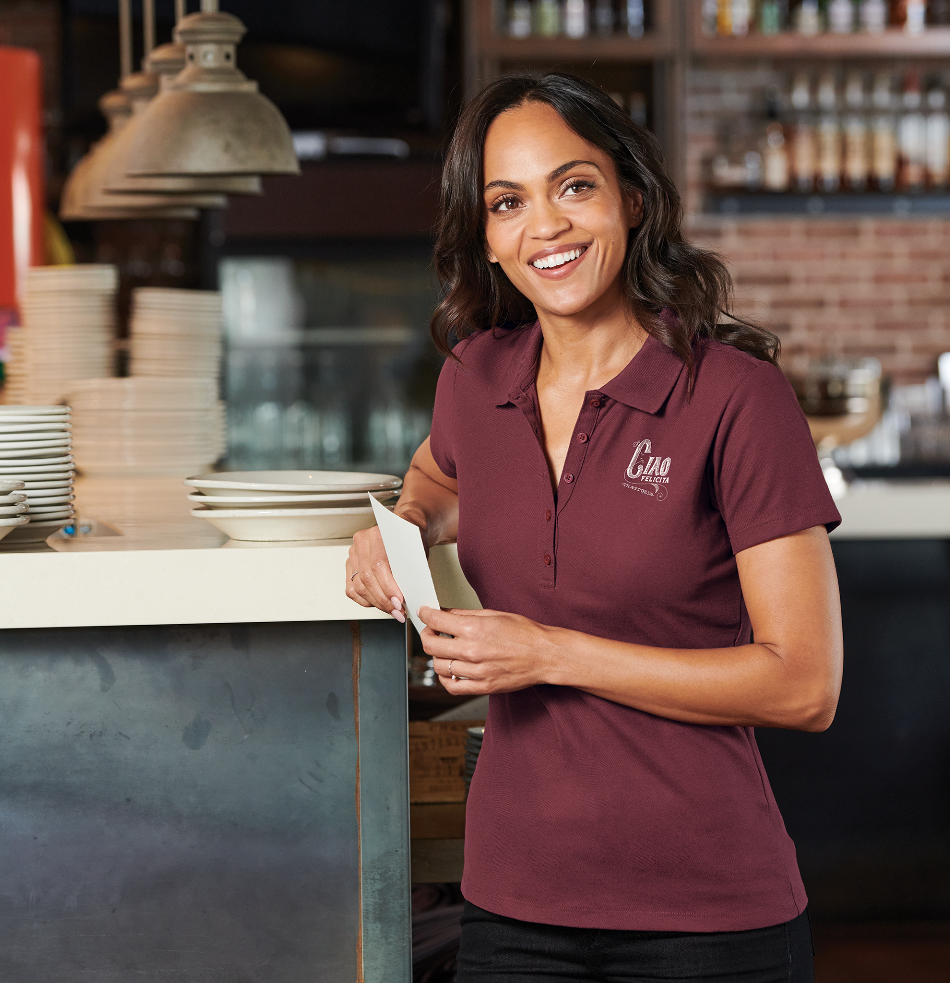  Restaurant employee in a branded burgundy polo supplied by Righteous Clothing Agency. 