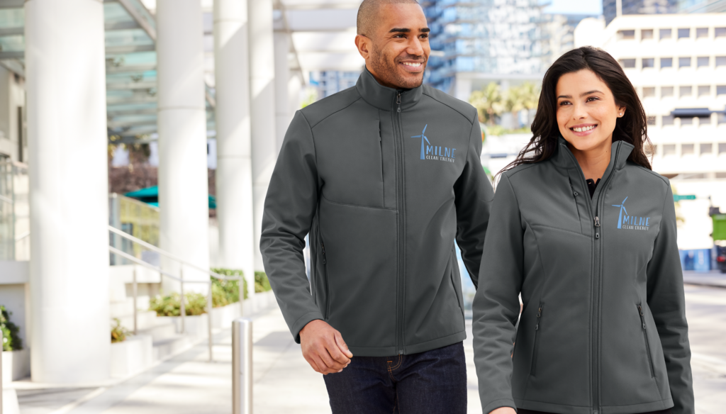 Two employees wearing Righteous-branded gray softshell jackets outdoors.