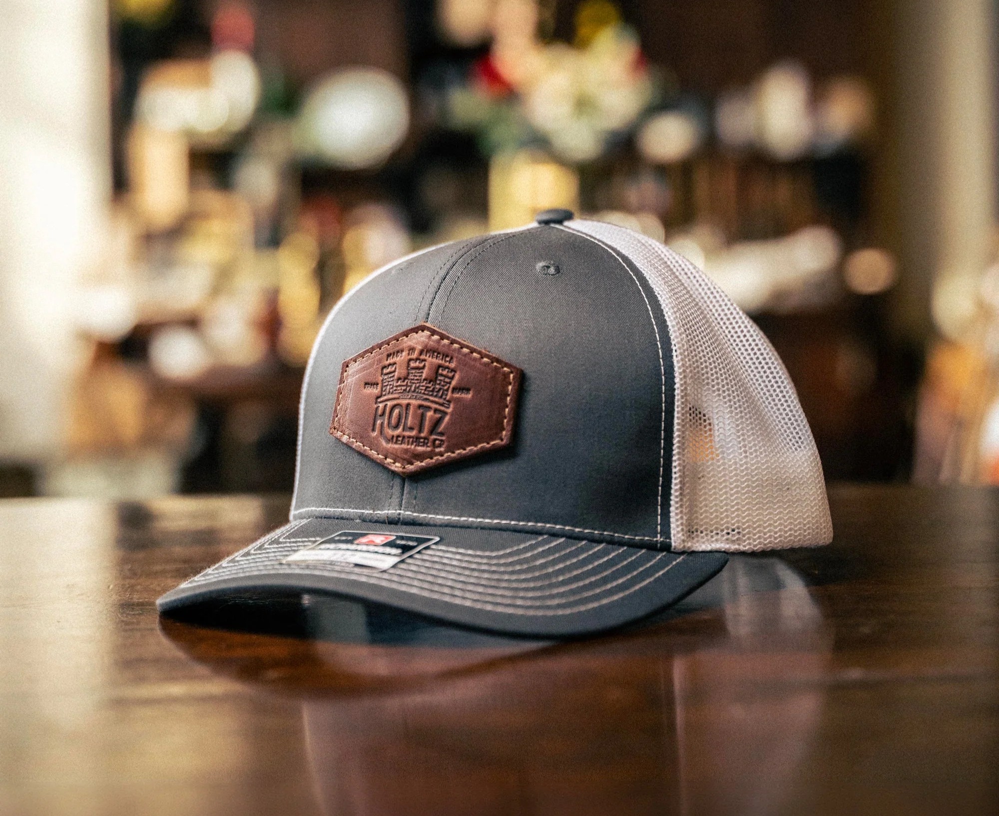 Righteous custom trucker hat with leather patch displayed on a wooden bar.