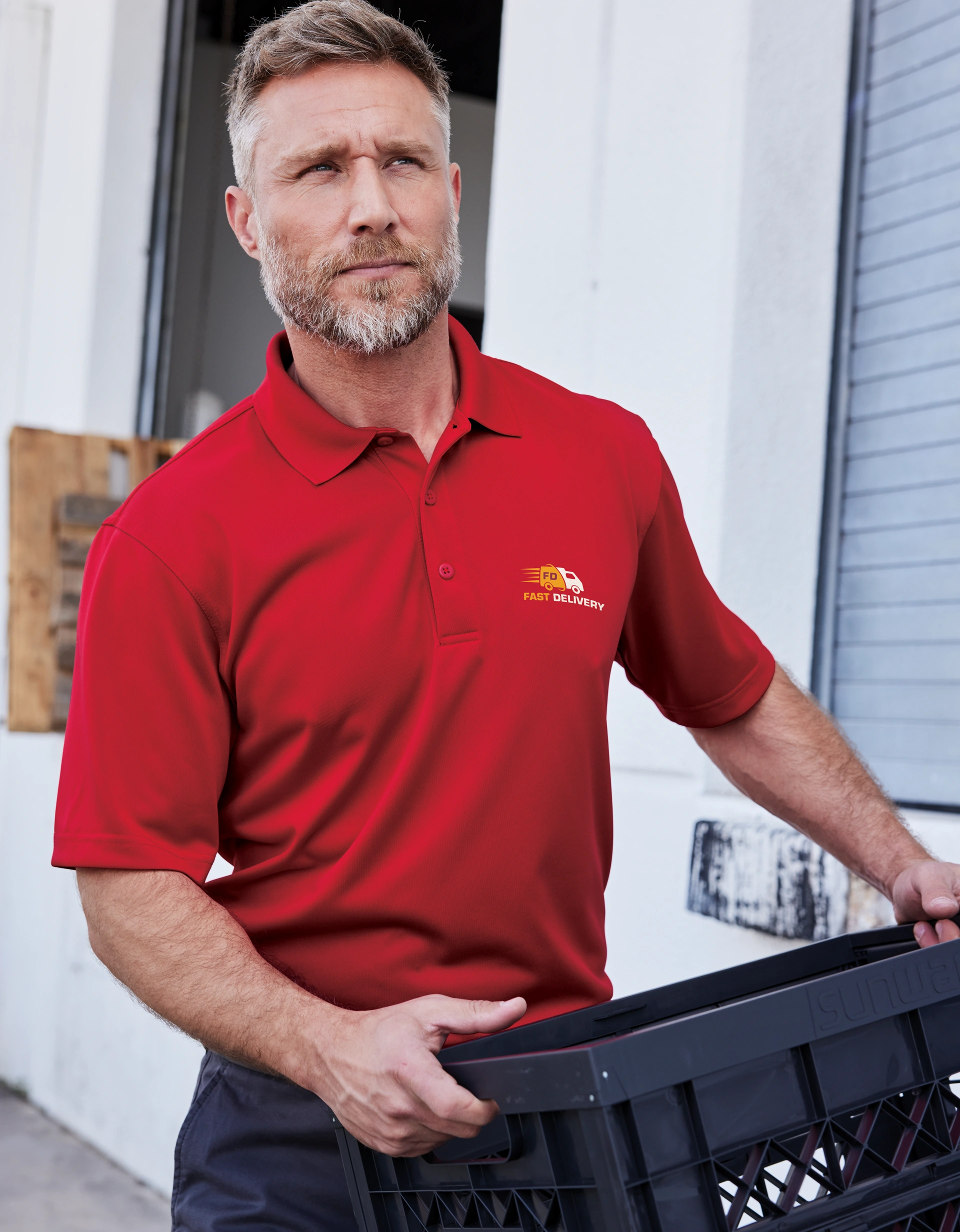 Man in red polo shirt from Righteous holding black crate outdoors.